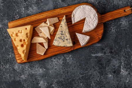 Assorted cheeses on wooden board, top view, copy space.の写真素材