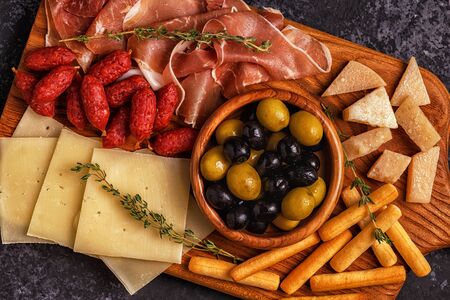 Sausage olives prosciutto cheese bread sticks wine.の写真素材