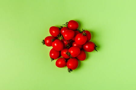 Tomatoes on a green pastel background, top view.の写真素材