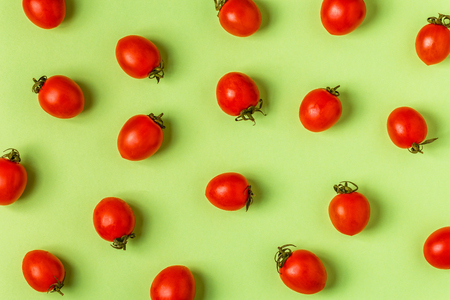 Tomatoes on a green pastel background, top view.の写真素材