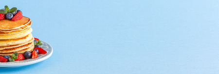 Pancakes with berries on a bright pastel background, copy space.の写真素材
