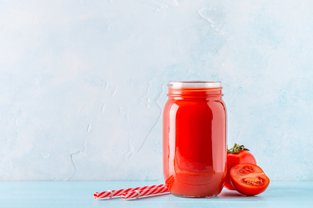 Tomato juice in a jar on a blue backgroundの写真素材