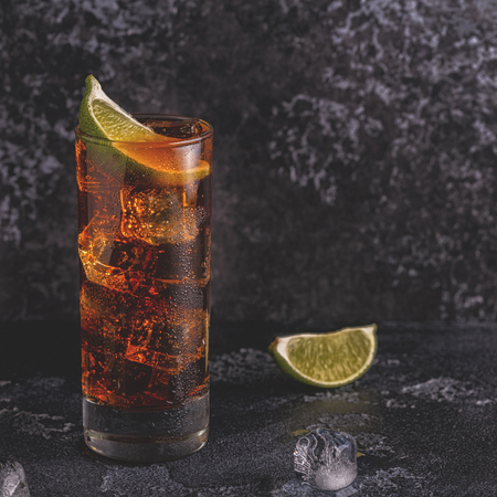 Rum and cola cuba libre with lime and ice, selective focus.の写真素材