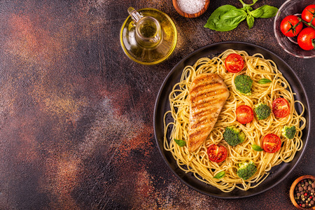 Plate of spaghetti tomato broccoli chicken,  concept of  healthy diet foodの写真素材