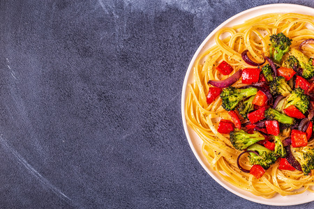 Pasta with broccoli, pepper, onion, top view.の写真素材