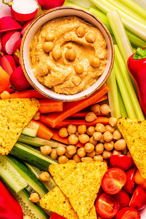 Hummus with various fresh raw vegetables, top view.の写真素材
