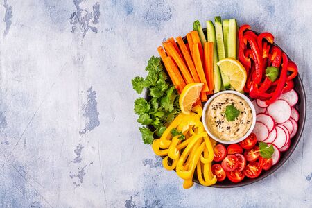 Homemade hummus with fresh vegetables, top view.の写真素材
