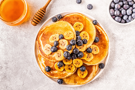 Pancakes with banana,  blueberries on white plate, selective focus.の写真素材