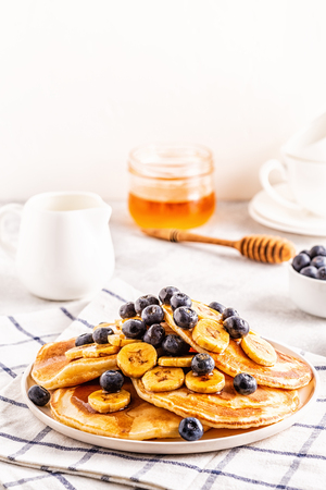 Pancakes with banana,  blueberries on white plate, selective focus.の写真素材