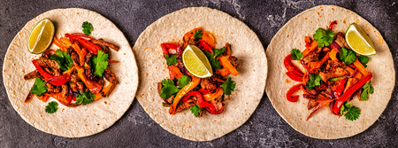 FAJITAS with colored pepper and onions, served with tortillas, salsa and sour cream.の写真素材