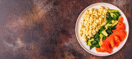 Ketogenic diet breakfast, scrambled eggs, salmon, avocado, spinach, top view.の写真素材