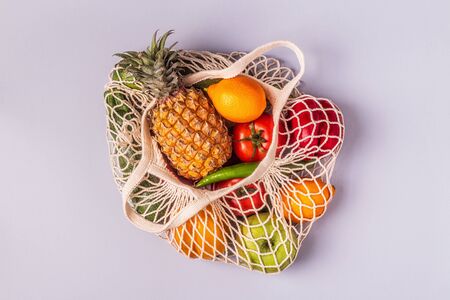 Fresh vegetables and fruits in bag mesh, top view.の写真素材