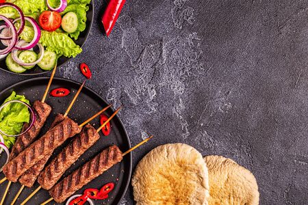 Traditional middle eastern, arabic or mediterranean meat kebab with vegetables and pita bread. Top view.の写真素材