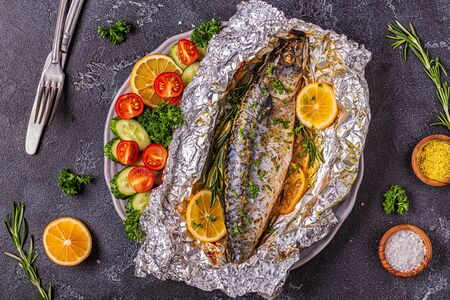 Mackerel baked in foil with vegetables on a dish, top viewの写真素材