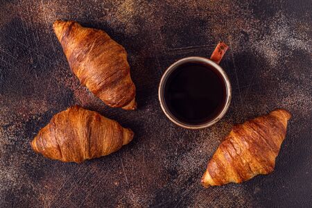 Coffee and croissant on stone background. French breakfast. Top view with copy space.の写真素材