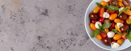 Italian caprese salad with tomatoes, mozzarella cheese, basil, olive oil, top view.の写真素材