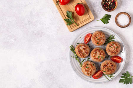 Fresh chiken cutlets with tomatoes and rosemary, top view