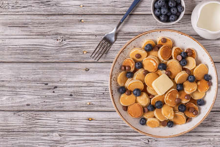 Trendy breakfast with mini pancakes, blueberries and chocolate chips, top view.の写真素材