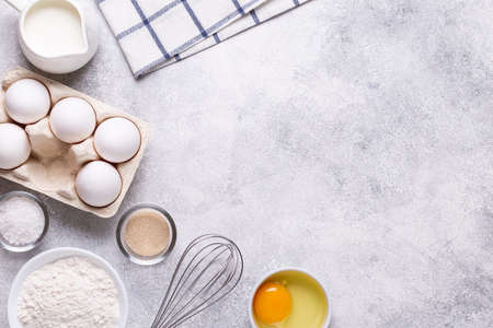 Ingredients for baking - flour, milk, salt, sugar, eggs. Top view, copy space.