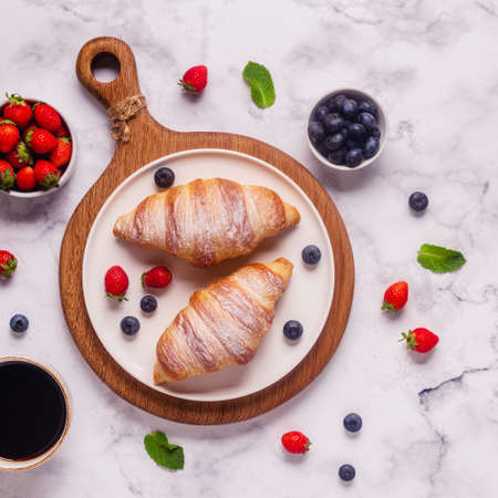 Breakfast with croissants and fresh fruits, top view.の写真素材