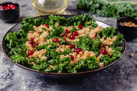 Healthy raw kale and quinoa salad with cranberry and pine nut. Selective focus.の写真素材