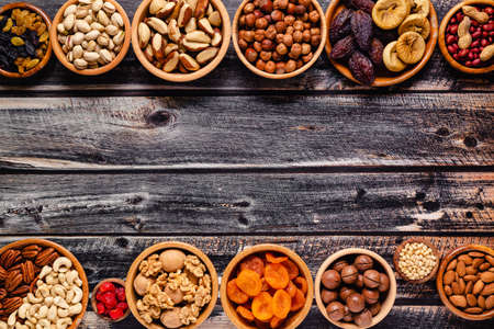 Various Nuts and dried fruits in wooden bowls, top view.の写真素材