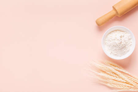 Ingredients for baking on light pink background, space for text.