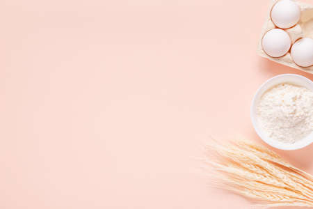 Ingredients for baking on light pink background, space for text.