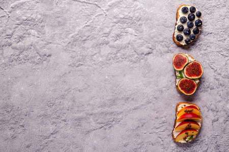 Homemade summer toast with cream cheese, nut butter and fruits and berries, top view.の写真素材