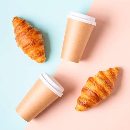 Coffee to go in a paper cup with croissants, top view.の写真素材