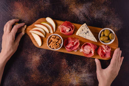 Serving board with meat and cheese snacks, top view.の写真素材