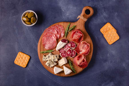 Serving board with meat and cheese snacks, top view.の写真素材