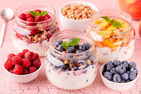 Healthy breakfast. Granola / muesli yoghurt and fruit served in glass jars.の写真素材