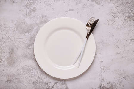 Clean empty white plate with cutlery. Copy space, mock up, top view. Concept for menu with utensil.の写真素材