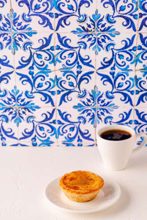 Egg tart, traditional Portuguese dessert, pastel de nata / pastel de belem. Azulejo tile background.