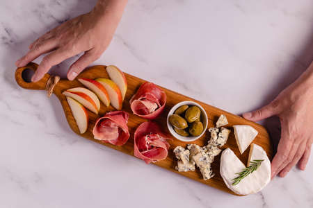 Serving board with meat and cheese snacks, top view.の写真素材