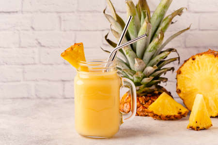Tropical pineapple smoothie in a mason jar, selective focus.の写真素材