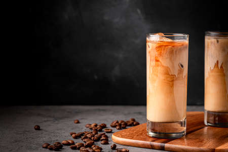 Ice coffee in a glass with cream poured over. Cold summer drink.