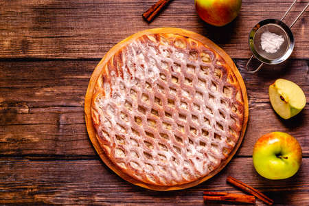 Homemade apple pie with cinnamon on a wooden background. Top view.の写真素材