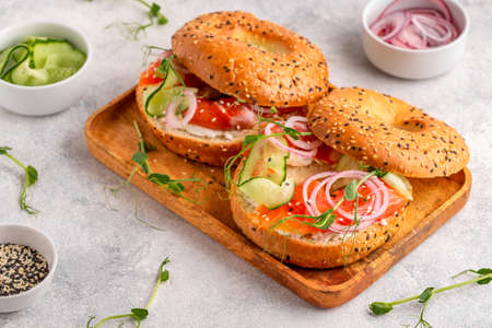Bagel and salmon lox with cream cheese, cucumbers, onions and microgreens.の写真素材
