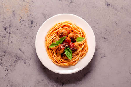 Spaghetti with meatballs and tomato sauce on a stone background, top viewの写真素材