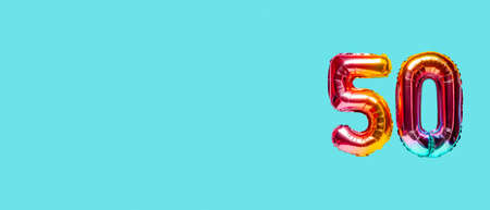 Rainbow foil balloon number, digit fifty. top view. Colored numeral on blue background.の写真素材