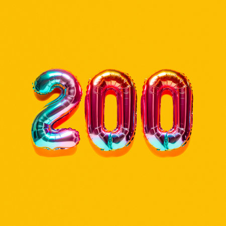 Rainbow foil balloon number, digit two hundred. top view. Colored numeral on yellow background.の写真素材