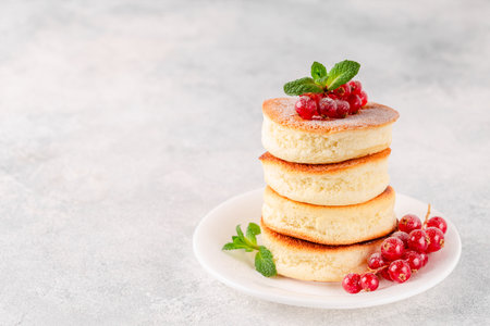 Japanese soft pancakes with berries sprinkled with powdered sugarの写真素材