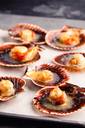 Cooked scallops with melted butter on a baking sheet