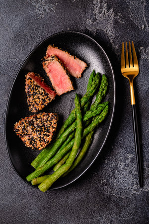 Tuna steak fried in sesame seeds served with asparagus. Healthy, diet food.の写真素材