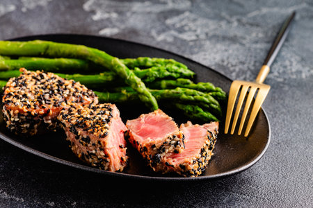 Tuna steak fried in sesame seeds served with asparagus. Healthy, diet food.の写真素材