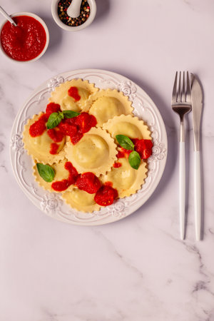 Ravioli with tomato sauce and basil on white plate.の写真素材