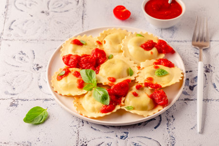 Ravioli with tomato sauce and basil on white plate.の写真素材