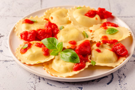 Ravioli with tomato sauce and basil on white plate.の写真素材